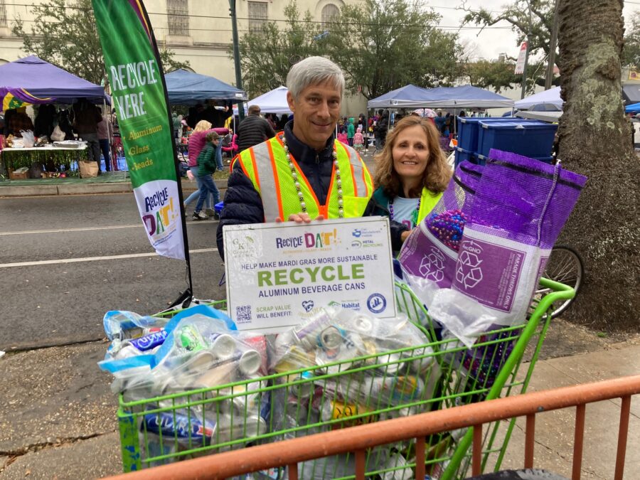 volunteers standing with an oversized shopping cart full of cans